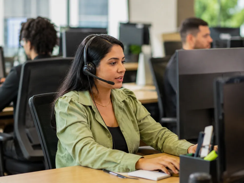 Especialista de atendimento com headset em escritório claro